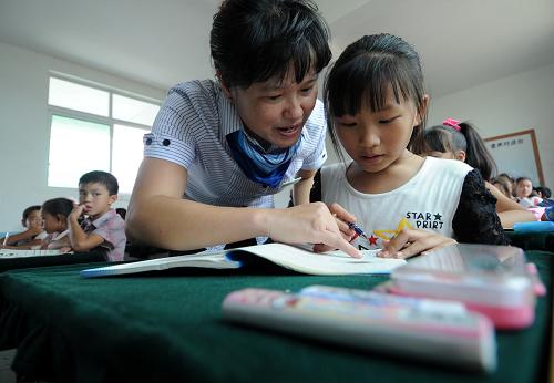 南丰县莱溪乡中心小学六年级数学老师在为一名学生讲解课本知识